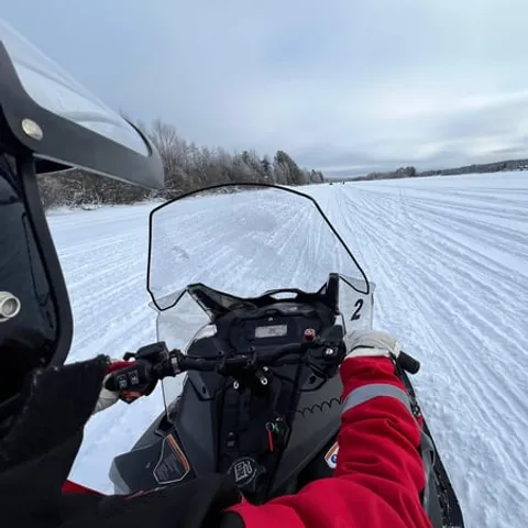 The rider's view over the handlebars on an open snow plain