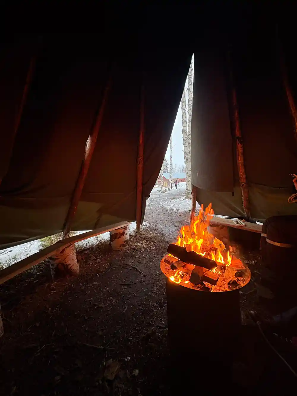 Campfire burning inside traditional tent structure