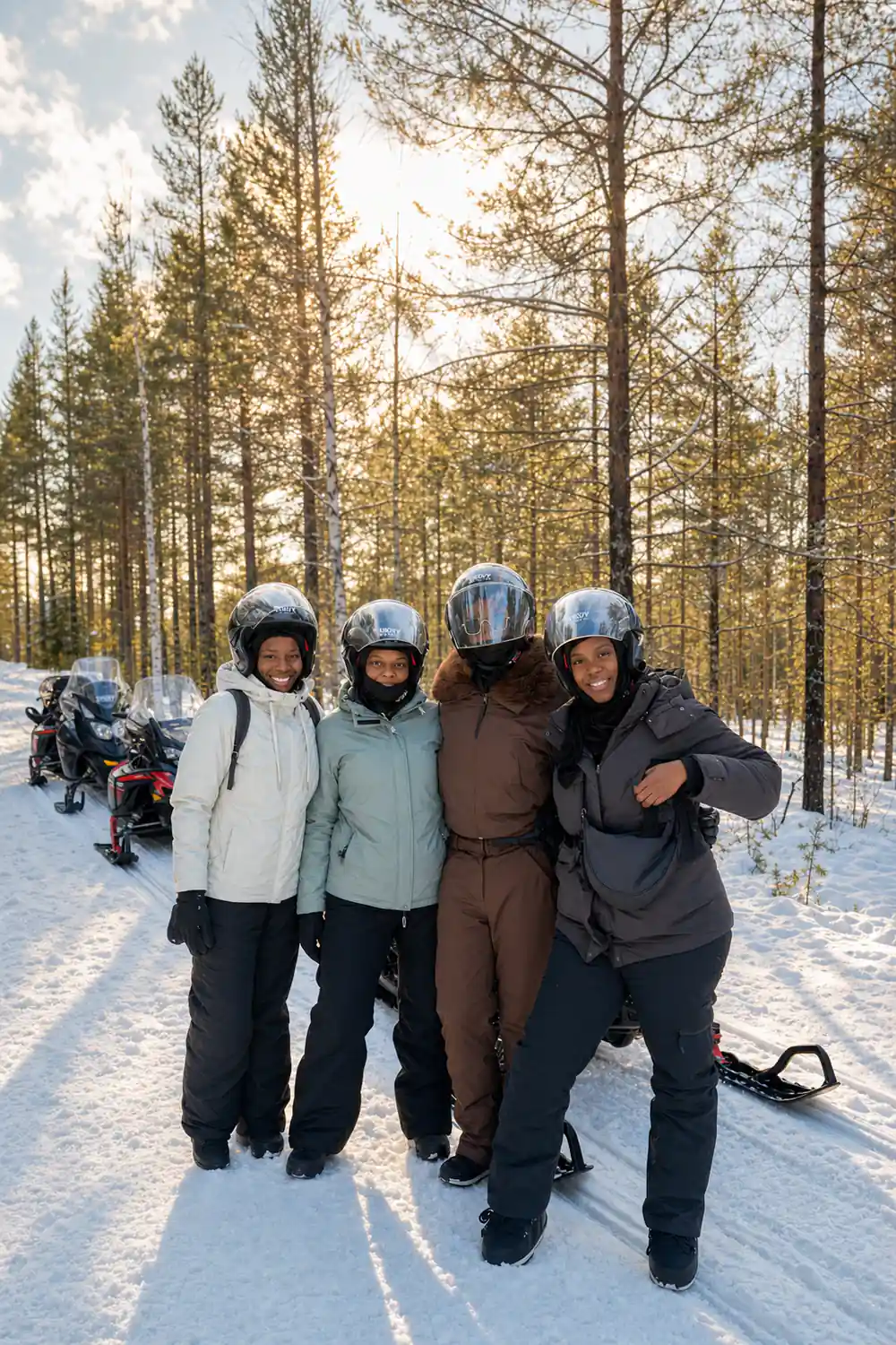 Four people in winter clothing standing together outdoors