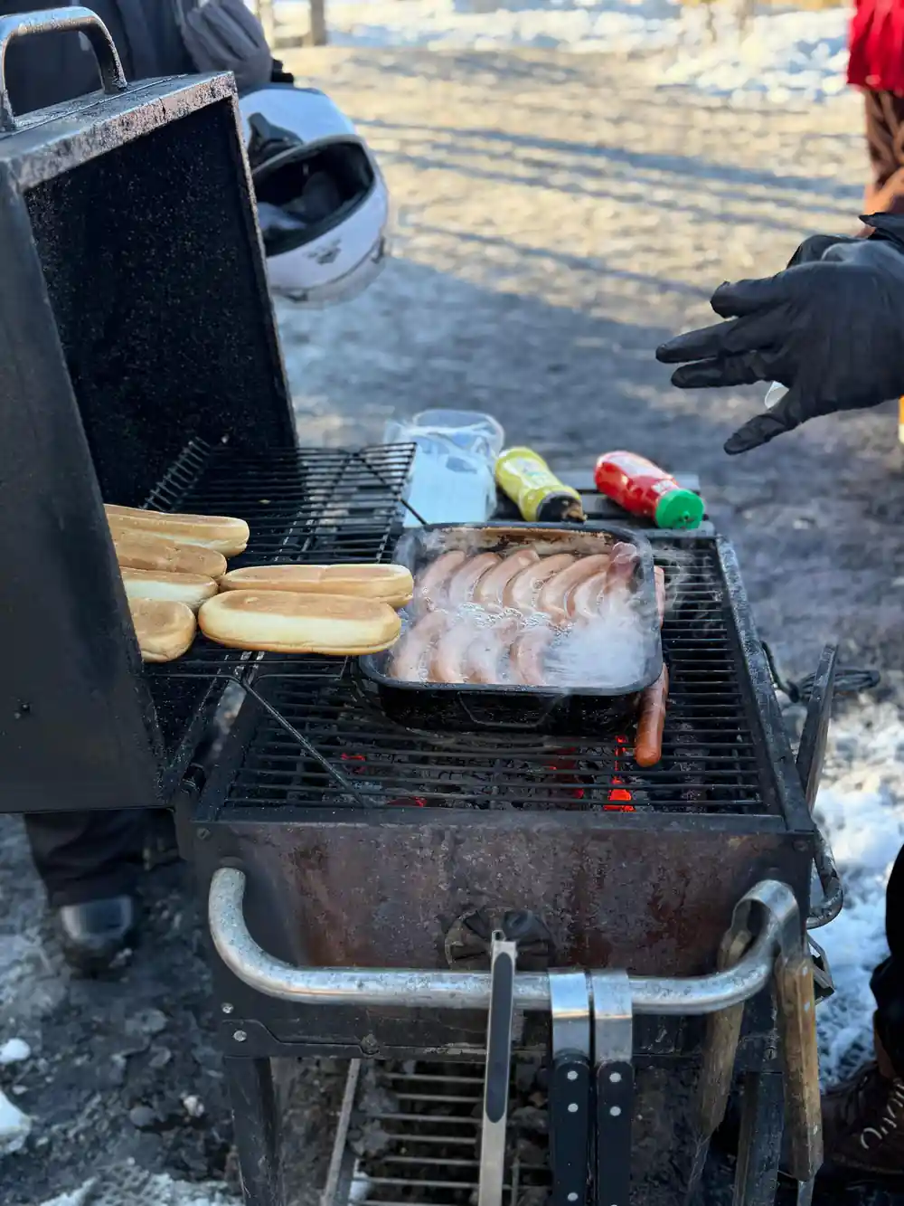 Grilled meat and vegetables on portable barbecue in snow