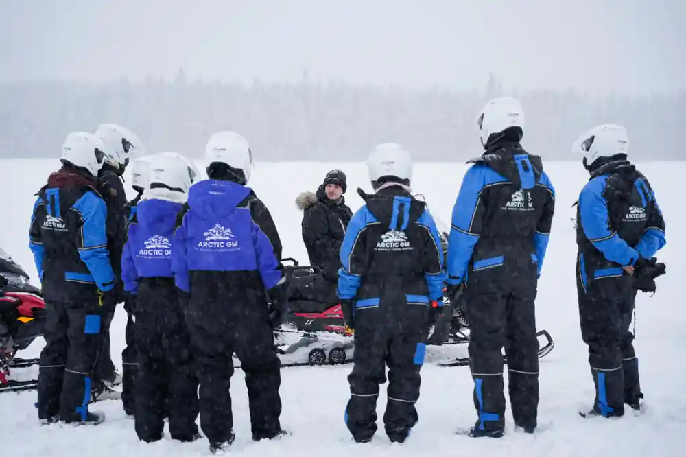 Group standing in winter clothing on snowy ice field
